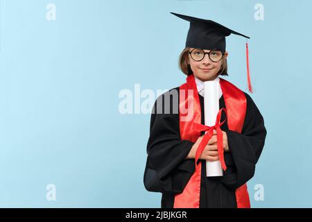 Whizz Kid 9-11 Jahre Mädchen trägt Abschlusskappe, runde Brillen und Zeremonie Robe mit Zertifikat Diplom auf hellblauem Hintergrund. Abschlussfeier Stockfoto