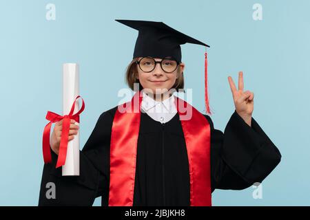 Whizz Kid Girl 9-11 Jahre Mädchen trägt Abschlusskappe, runde Brillen und Zeremonie Robe mit Zertifikat Diplom auf blauem Hintergrund. Untergeordnetes Element hat eine Position Stockfoto