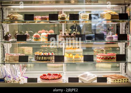 Glasvitrine mit Konditorei mit verschiedenen Kuchen und Gebäck Stockfoto