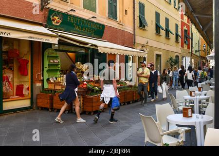 Straßenansicht des alten Fischerdorfes der italienischen Riviera mit einem Lebensmittelgeschäft und einem Straßencafé, Santa Margherita Ligure, Genua, Ligurien, Italien Stockfoto