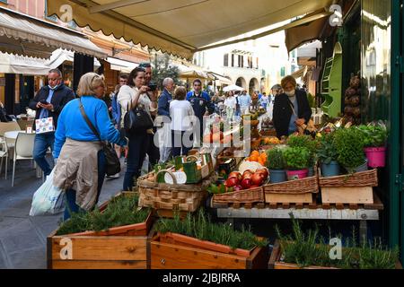 Obst, Gemüse und aromatische Kräuter wurden vor einem Lebensmittelgeschäft in einer überfüllten Straße des alten Fischerdorfes Santa Margherita Ligure, Genua, ausgestellt Stockfoto