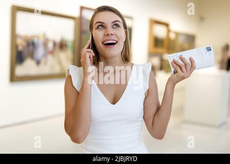 Frau, die im Museum telefoniert Stockfoto