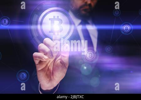 Geschäftsmann, der mit Bitcoin-Kryptowährung auf einem virtuellen digitalen Bildschirm handelt, selektiver Fokus Stockfoto