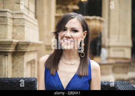 Multirassische hübsche lächelnde Frau in blauem Kleid im Freien Porträt Stockfoto