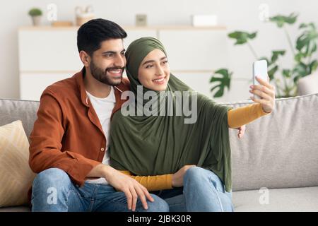 Happy Muslim Ehemann Und Ehefrau Machen Selfie Auf Smartphone Indoor Stockfoto