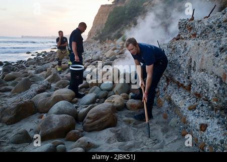 7. Juni 2022, Montecito, CA, USA: Feuerwehrleute der Feuerwehr Montecito haben am 6. Juni 2022 am Butterfly Beach, einem typisch unberührten Küstenstreifen in einer der exklusivsten und reichsten Städte der USA, ein wüstendes Lagerfeuer ausgelöst, das von einem wohlmeinenden, aber fehlgeleiteten Bewohner von Goleta, Kalifornien, namens Joey, begonnen wurde. Die, verärgert über die Trümmer, die vom verlassenen und illegalen Obdachlosenlager am Butterfly Beach hinterlassen wurden, das Feuer anzündete, um den Müll zu verbrennen. Dies dauerte weniger als 24 Stunden, nachdem die Feuerwehrleute gekämpft und das nahegelegene Brückenfeuer eingedämmt hatten, sodass Bewohner und Ersthelfer besonders nervös waren und vi Stockfoto