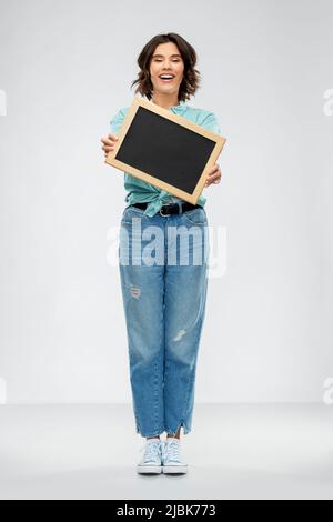 Porträt einer lächelnden Frau mit schwarzer Kreidetafel Stockfoto