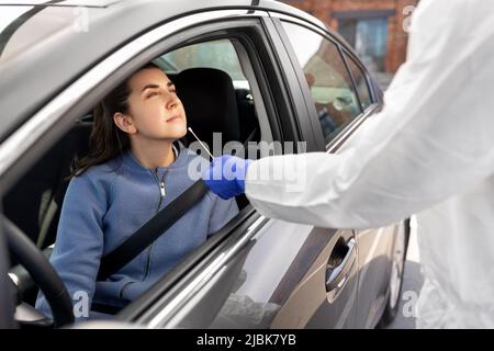 Mitarbeiter im Gesundheitswesen, die Coronavirus-Tests im Auto durchführen Stockfoto