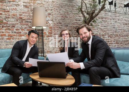 Multinationale Geschäftsleute führen Brainstorming bei einem Büromeeting durch. Multiethnische professionelle Mitarbeiter sprechen im Team engagiert in der Teamarbeit diskutieren impro Stockfoto