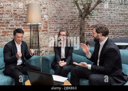 Multinationale Geschäftsleute führen Brainstorming bei einem Büromeeting durch. Multiethnische professionelle Mitarbeiter sprechen im Team engagiert in der Teamarbeit diskutieren impro Stockfoto