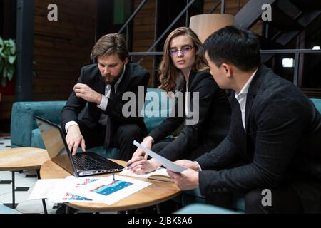 Multinationale Geschäftsleute führen Brainstorming bei einem Büromeeting durch. Multiethnische professionelle Mitarbeiter sprechen im Team engagiert in der Teamarbeit diskutieren impro Stockfoto
