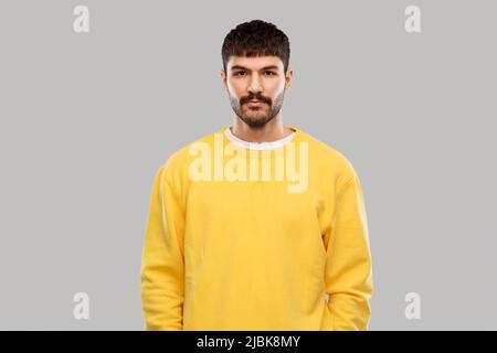 Junger Mann im gelben Sweatshirt Stockfoto