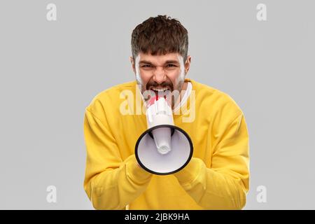 Wütender Mann, der zu einem Megaphon schreit Stockfoto