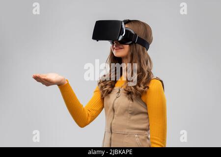 Teenager-Mädchen in vr Brille auf grauem Hintergrund Stockfoto