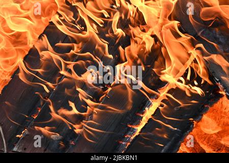 Flammen wüten durch Holzschiefer, leuchtendes Feuer und Flammen Stockfoto