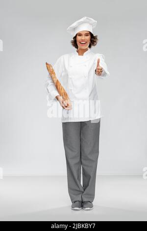 Glückliche Köchin mit französischem Brot oder Baguette Stockfoto