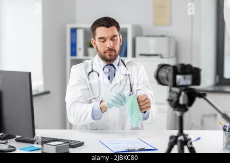 Männlicher Arzt mit Handschuhen Aufnahme Video Blog Stockfoto