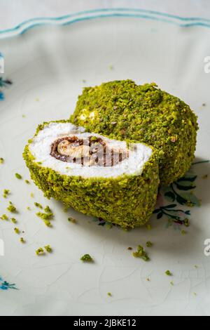 Türkische spezifische Dessert-Muska Pestil mit Pistazien-Pulver und Haselnuss-Schokolade-Creme . Amulett. Bereit zum Essen. Stockfoto