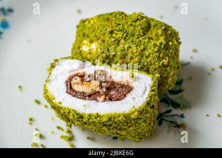 Türkische spezifische Dessert-Muska Pestil mit Pistazien-Pulver und Haselnuss-Schokolade-Creme . Amulett. Bereit zum Essen. Stockfoto