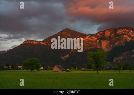 Dämmerung nach dem Sonnenuntergang in Dornbirn, Vorarlberg, Österreich. Tolle Stimmung mit interessanteren graublau Wolken, grünen Wiesen und Haus Stockfoto