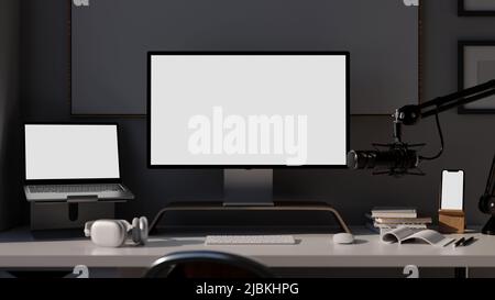 Modernes, dunkles Sendestudio mit Laptop, Smartphone und Computer, leerer Bildschirm auf dem Tisch, modernes Mikrofon. Heimradiosender, Live-st Stockfoto
