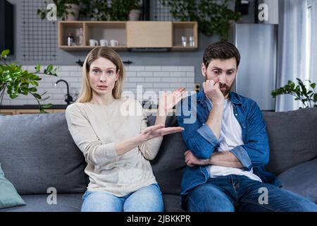 Familienkonflikt. Junges Paar, Familie, Mann und Frau bei einem Empfang beim Psychologen. Setzen Sie sich auf die Couch, sprechen Sie, zeigen Sie, diskutieren Sie, argumentieren Sie. Stockfoto