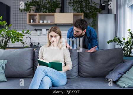 Ein böser Ehemann streitet zu Hause und schlägt seine Frau, Familienkonflikt Stockfoto