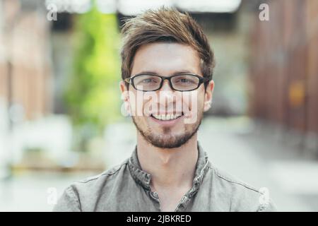 Porträt eines jungen Studenten, glücklicher Mann mit Brille Blick auf Kamera Nahaufnahme Foto Stockfoto