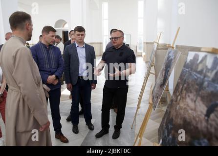 BUCHA, UKRAINE - 6. JUNI 2022 - erster Vizepräsident des Riigikogu von Estland Hanno Pevkur (2. L) betrachtet die Fotografien von Massenbestattung von Stockfoto