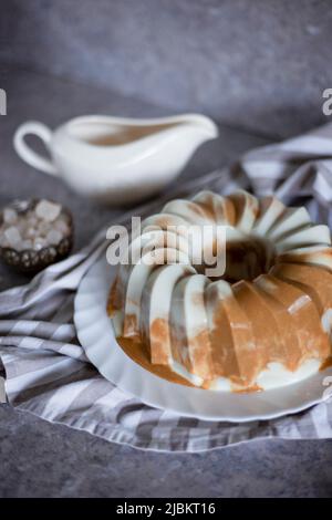 Frühstückspudding. Schokoladenkaffee Milch Gelee Kuchen zum Nachtisch. Süßes Essen auf dem Tisch. Stillleben. Grauer Hintergrund Stockfoto