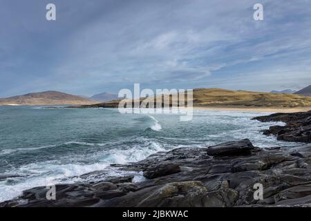 Am Strand Tràigh IAR in der Nähe von Horgabost auf der Isle of Harris, Schottland, rollt eine Welle. MacLeods Stein ist nur in der Mitte des Rahmens sichtbar Stockfoto