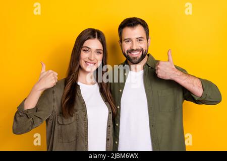 Porträt von fröhlichen freundlichen Menschen Handfinger demonstrieren Daumen nach oben isoliert auf gelbem Hintergrund Stockfoto