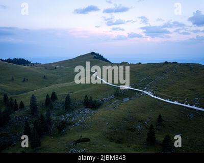 Drohnenperspektive Aufnahme des Naturspaziergangs im Grasland der velika planina in den himmlischen kamnik-alpen sloweniens Stockfoto