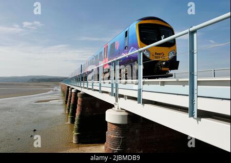 Ein erster Zug der Schiene, der das Viadukt von Kent im Dorf Arnside Cumbria in Großbritannien überquert Stockfoto