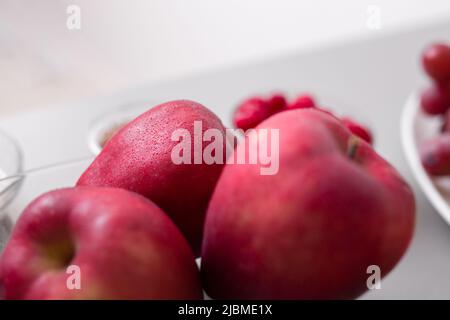 Frische Äpfel in einer Glasschüssel auf der Küchentheke, gesunde Ernährung. Stockfoto