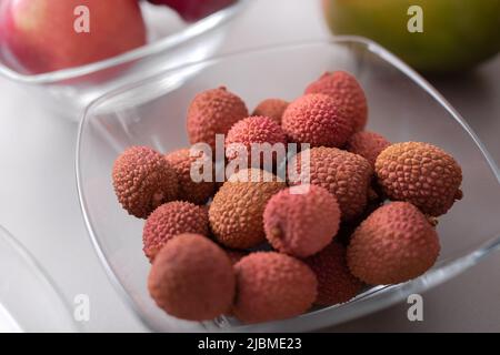 Frische Litschis in einer Glasschüssel auf der Küchentheke, gesunde Ernährung. Stockfoto