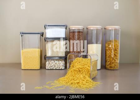 Behälter zur Lagerung von Schüttgütern in der Küche. Selektiver Fokus auf eine Dose Pasta. Stockfoto