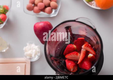 Rohe Erdbeeren im Mixer bereit, um frischen hausgemachten Smoothie zu machen. Gesundes Lifestyle-Konzept Stockfoto