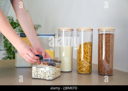 Behälter zur Lagerung von Schüttgütern in der Küche. Selektiver Fokus auf eine Dose Bohnen. Stockfoto