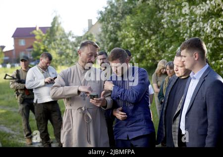 Bucha, Ukraine - 6. Juni 2022 - der erste Vizepräsident des estnischen Riigikogu Hanno Pevkur (2. L) spricht mit dem Leiter der Kirche des hl. Andreas, dem ersten Apostel Andrii Halavin, Bucha, Region Kiew, Nordukraine. Auf dem Gelände der Kirche des ersten Apostels Andreas wurde eine Massenbestattung von Zivilisten aus Bucha gefunden, die von russischen Invasoren getötet wurden. Dieses Foto kann nicht in der Russischen Föderation verteilt werden. Stockfoto