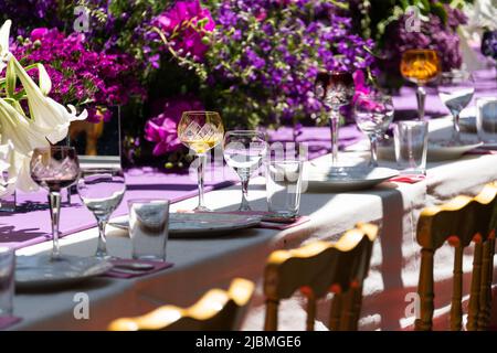 Gedeckte Feier-Esstisch mit leerem schönen Geschirr für den Urlaub im Freien in der Sommersonne Tag. Stockfoto