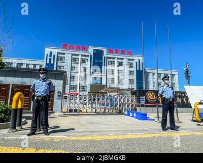 YILI, CHINA - 7. JUNI 2022 - Polizeibeamte stehen am ersten Tag der Aufnahmeprüfung des nationalen Colleges i Wache vor einem Untersuchungszentrum Stockfoto