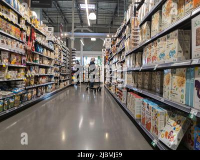 Kirkland, WA, USA - ca. September 2021: Weitansicht einer älteren Frau, die im Getreide- und Getreidegang in einem Whole Foods Market einkauft. Stockfoto