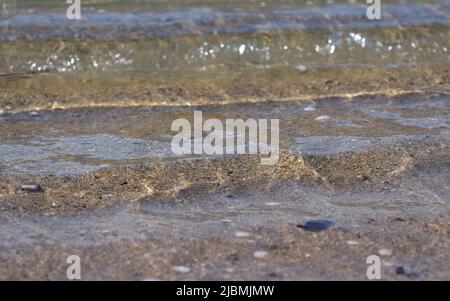 An einem sonnigen Sommertag, Cornwall, winzig kleine Wellen am Sandstrand Stockfoto