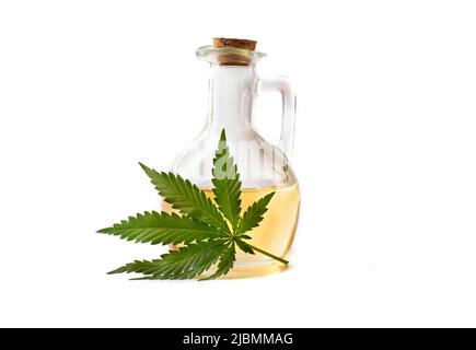 Gelbes Hanföl in einer Flasche mit einem Holzstopfen mit einem grünen Blatt der Cannabispflanze. Stockfoto