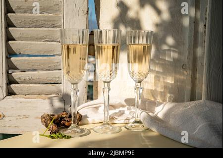 Drei Gläser französischer Champagner Sekt und Blick auf bunte Fischerboote im alten Hafen von Cassis, Provence, Frankreich, Sommerfest in PR Stockfoto