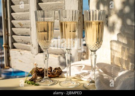 Drei Gläser französischer Champagner Sekt und Blick auf bunte Fischerboote im alten Hafen von Cassis, Provence, Frankreich, Sommerfest in PR Stockfoto