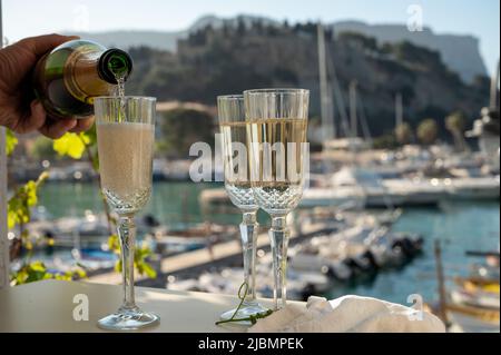 Drei Gläser französischen Champagner-Sekt und Blick auf bunte Fischerboote im alten Hafen von Cassis, Provence, Frankreich, Sommer Stockfoto