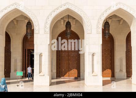 Gewölbte Tore und geschnitzte Holztüren führen zur Großen Moschee des Sultans Qaboos, Oman, Naher Osten Stockfoto