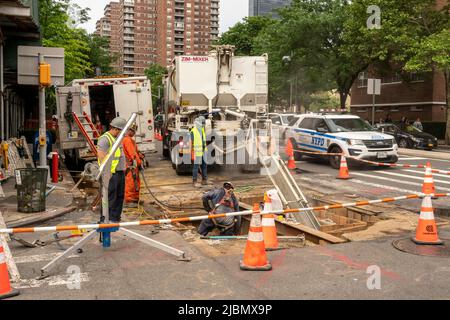 Nach Abschluss der Untertagearbeiten an der Ninth Avenue in Chelsea in New York am Samstag, dem 28. Mai 2022, gießen Arbeiter Zement in eine Ausgrabung auf der Straße. (© Richard B. Levine) Stockfoto